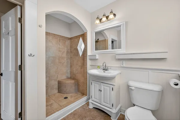 a bathroom with a toilet sink and mirror