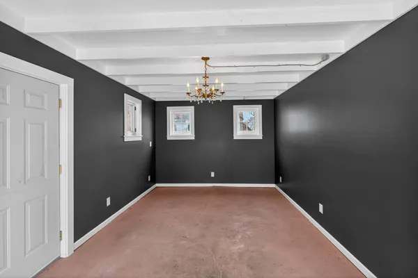 a view of a livingroom with a chandelier fan and windows