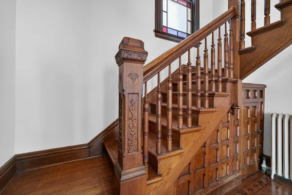 a view of staircase with lots of frames on wall and a window