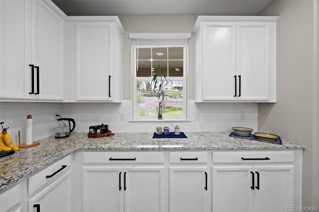 a kitchen with stainless steel appliances granite countertop white cabinets and a sink