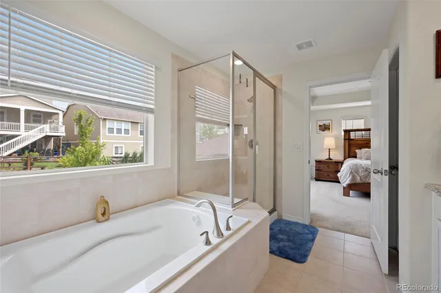 a en suite bathroom with a tub mirror and window