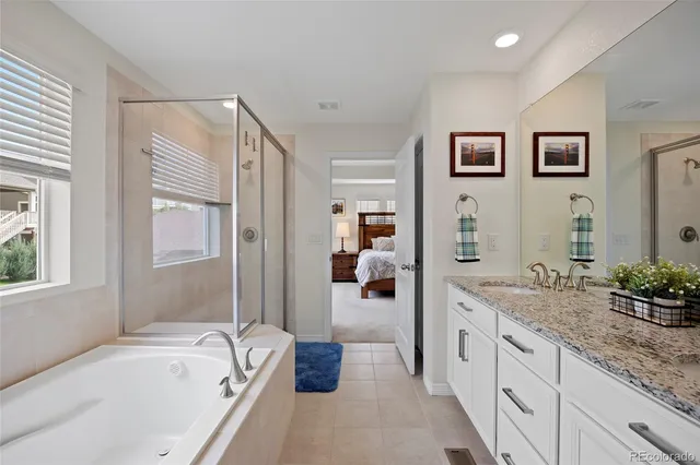 a spacious bathroom with a granite countertop tub sink and mirror