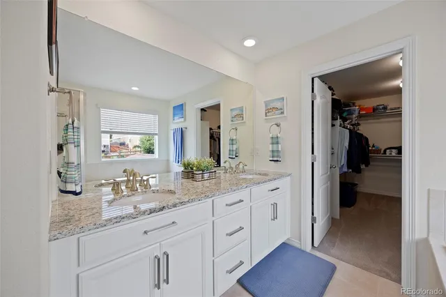a en suite bathroom with a granite countertop sink and mirror