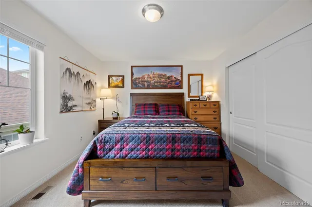 a bedroom with a bed and painting on the wall