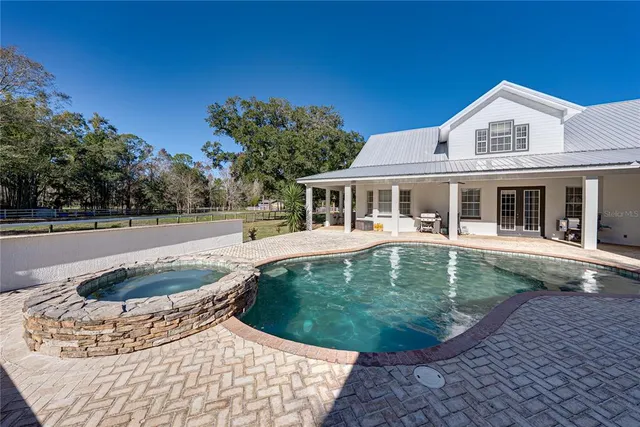 an aerial view of a house with swimming pool and patio