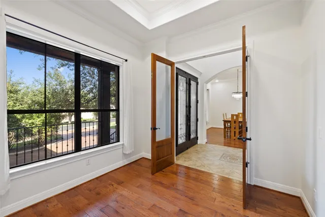 a view of a big room with wooden floor and windows