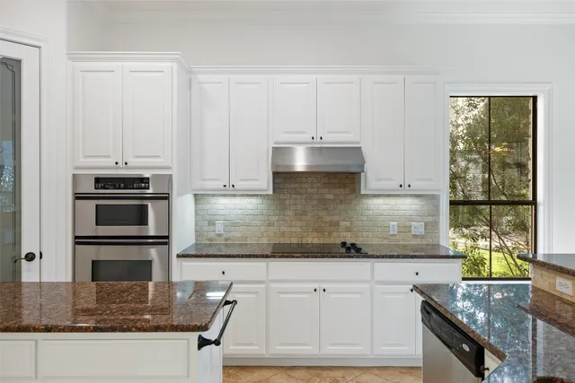 a kitchen with granite countertop a stove a sink and a counter space