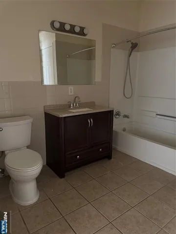 a bathroom with a toilet mirror vanity and tub