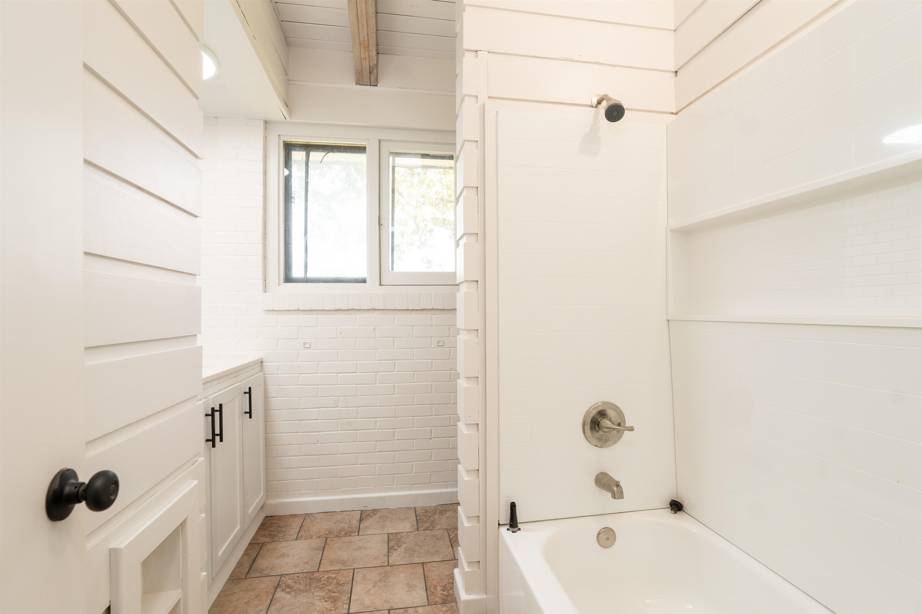 412 Wiley Parker Road Jackson, TN 38305 - Photo 11 of 28 a bathroom with a tub a sink a window and a shower