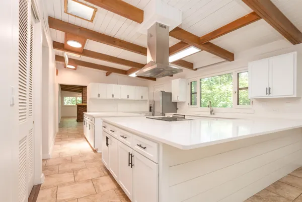 a kitchen with granite countertop a sink window and cabinets