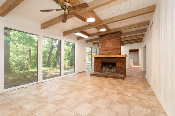 a view of empty room with fireplace and fan