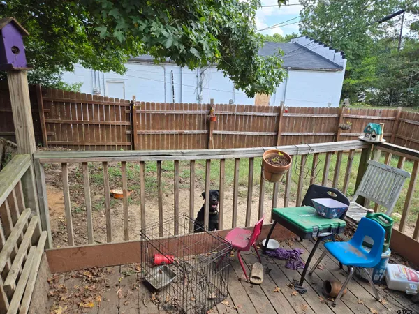 a view of a chairs and table on the deck in backyard