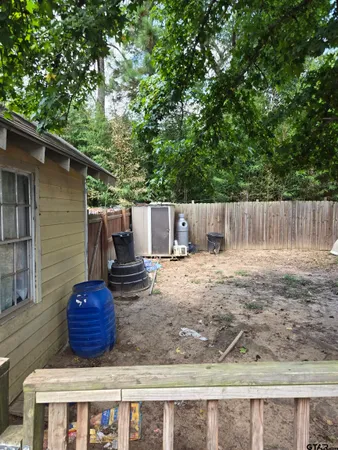 a view of a backyard with a barbeque and wooden fence