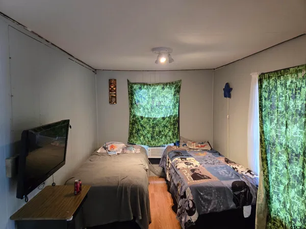 a bedroom with two beds and a flat screen tv