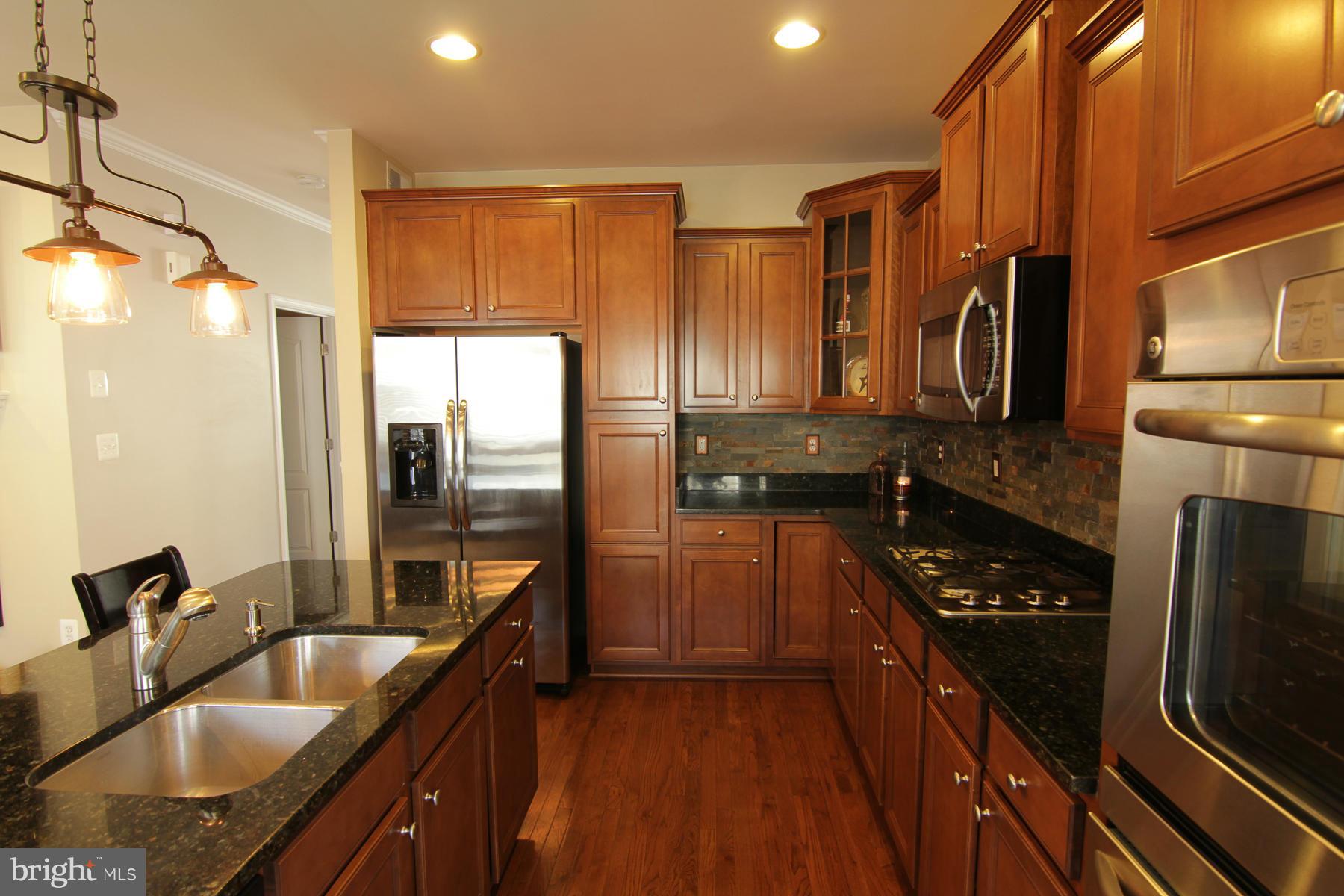 2651 Shade Branch Road Hanover, MD 21076 - Photo 18 of 30 a kitchen with kitchen island granite countertop a sink stove and refrigerator