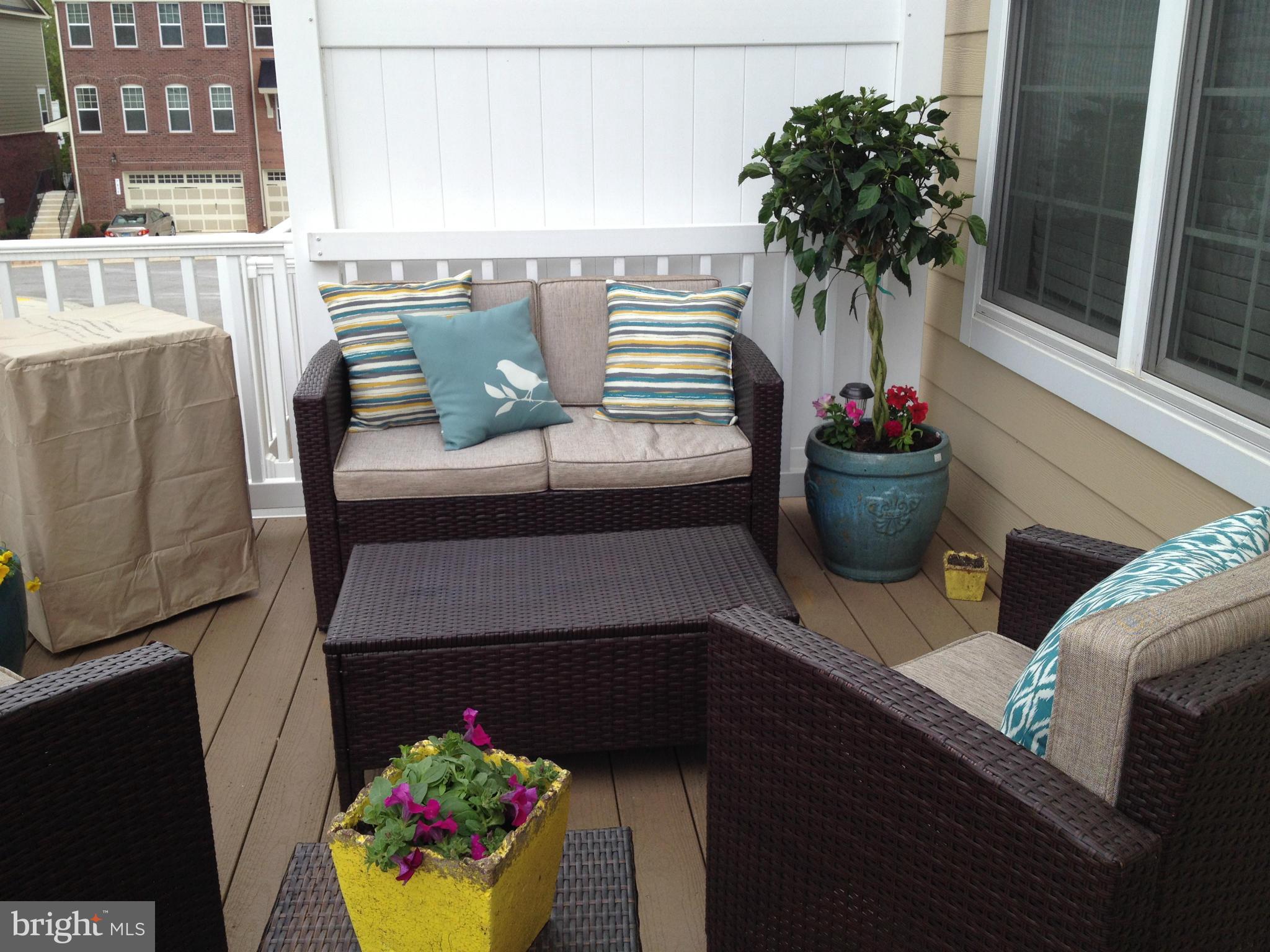 2651 Shade Branch Road Hanover, MD 21076 - Photo 7 of 30 a view of a balcony with dining table and chairs potted plants