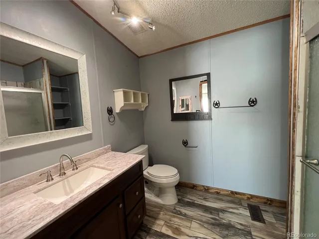 a bathroom with a granite countertop sink toilet and mirror