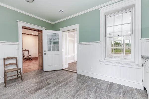 a view of an empty room with window and wooden floor