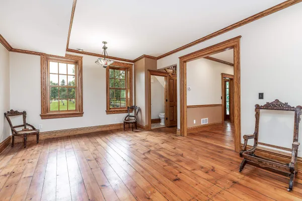 a view of an empty room with a window and a kitchen