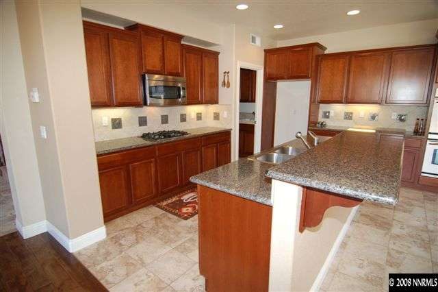 651 Aberdeen Court Reno, NV 89521 - Photo 4 of 9 a kitchen with stainless steel appliances granite countertop a sink refrigerator and cabinets