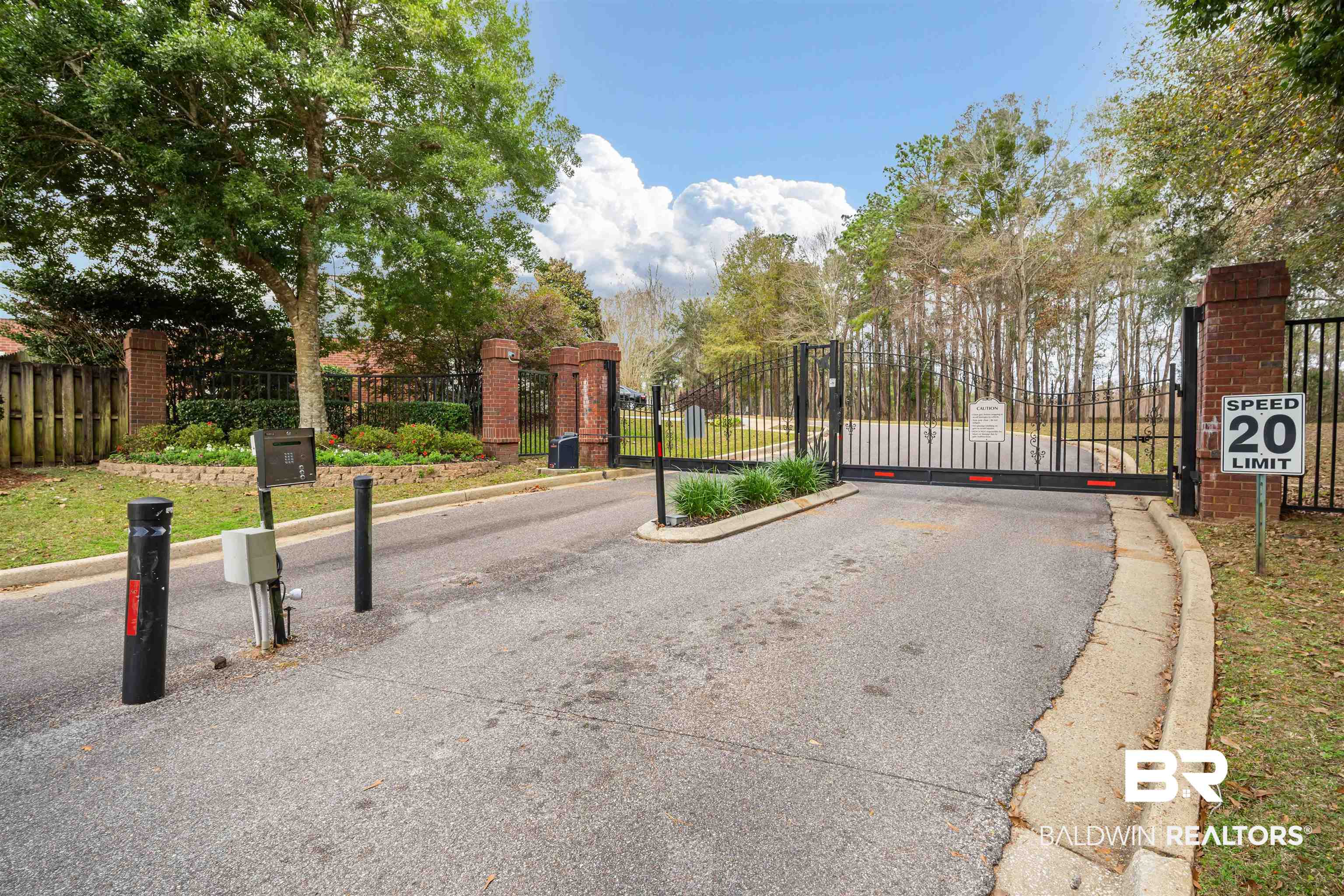 250 North Spring Lake Drive Mobile, AL 36695 - Photo 2 of 29 View of asphalt street with a gated entry, curbs, and a gate