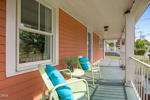a balcony with couple of chairs and a couch
