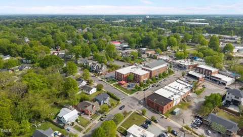 an aerial view of residential houses with outdoor space and trees all around