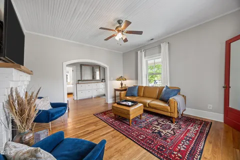 a living room with furniture a flat screen tv and a fireplace