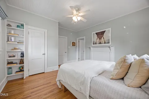 a bedroom with a bed chandelier and a window