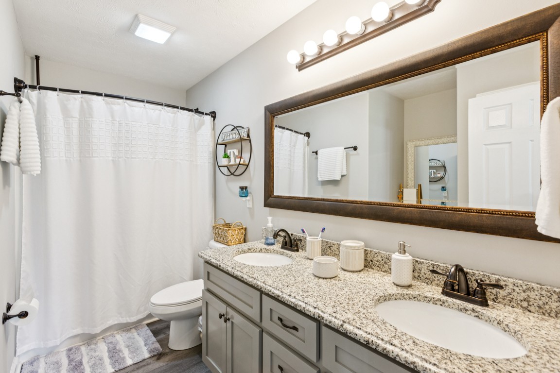 4510 Long Creek Road Lafayette, TN 37083 - Photo 16 of 25 a bathroom with a granite countertop sink and a mirror a toilet
