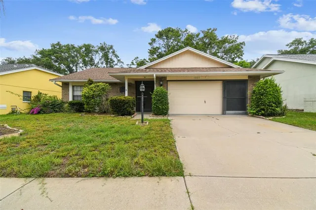 a front view of a house with a yard and potted plants