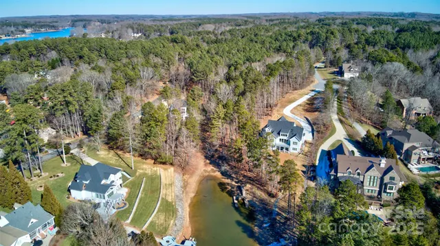 an aerial view of a house a yard and mountain