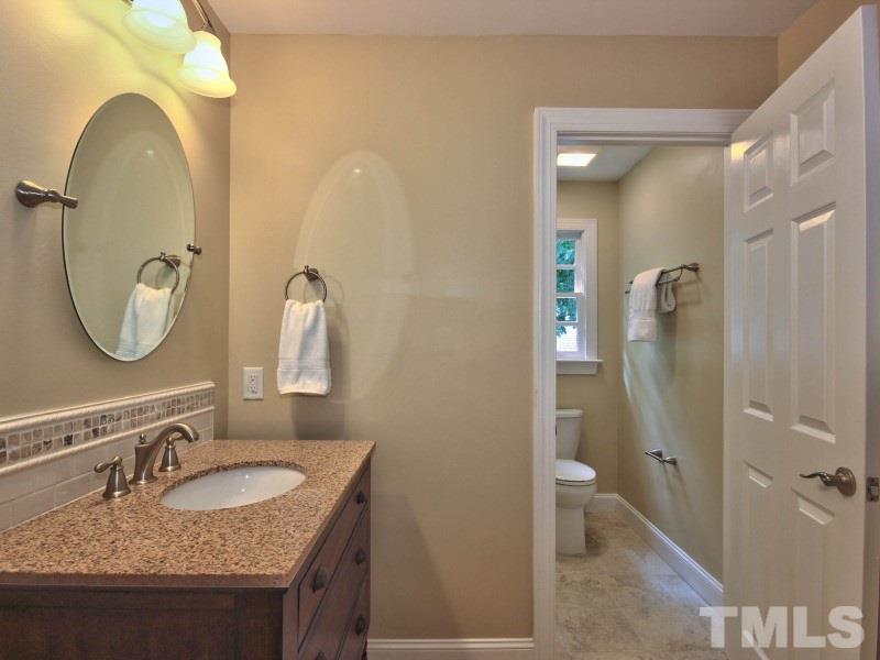 164 Yorkchester Way, Unit 13 Raleigh, NC 27615 - Photo 16 of 23 a bathroom with a granite countertop sink a toilet and a mirror