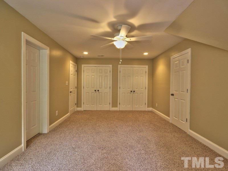 164 Yorkchester Way, Unit 13 Raleigh, NC 27615 - Photo 18 of 23 an empty room with a ceiling fan and a closet