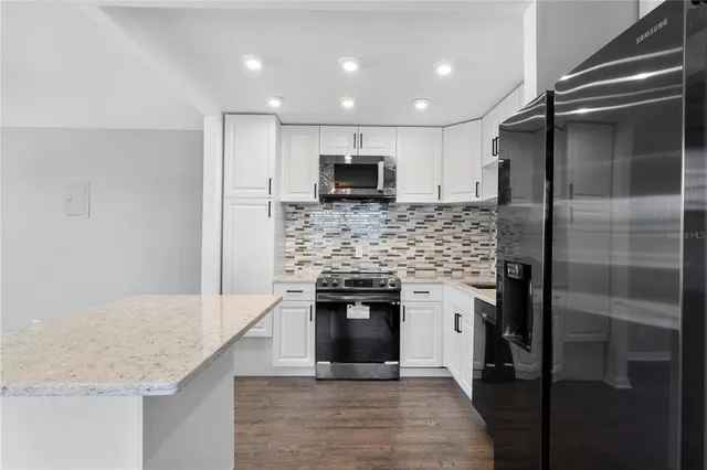 a kitchen with a refrigerator and a counter top space