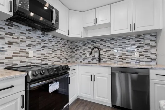 a kitchen with granite countertop a stove sink and cabinets