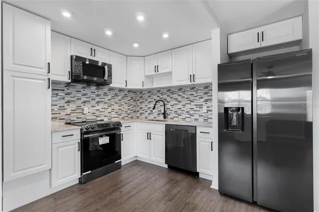a kitchen with stainless steel appliances kitchen island granite countertop a refrigerator and a stove top oven