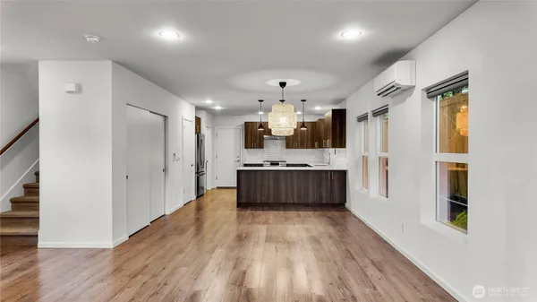 a large white kitchen with a large window a sink and stainless steel appliances