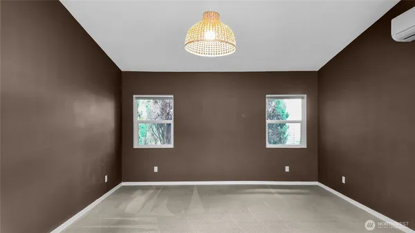 a view of an empty room with window and a bathroom