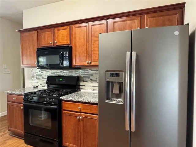 a kitchen with stainless steel appliances granite countertop a refrigerator stove and microwave
