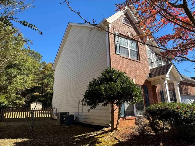 a front view of a house with a tree