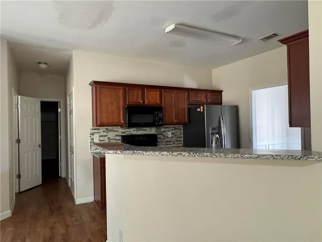 a view of a kitchen with a sink a refrigerator and a window