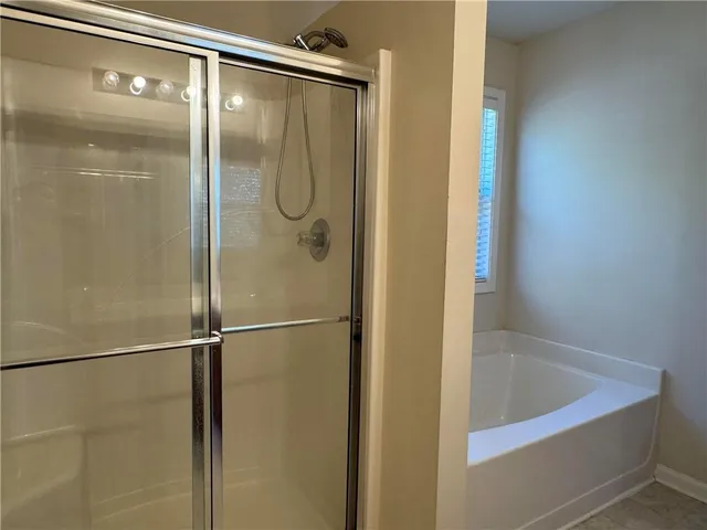 a bathroom with a shower and a bath tub