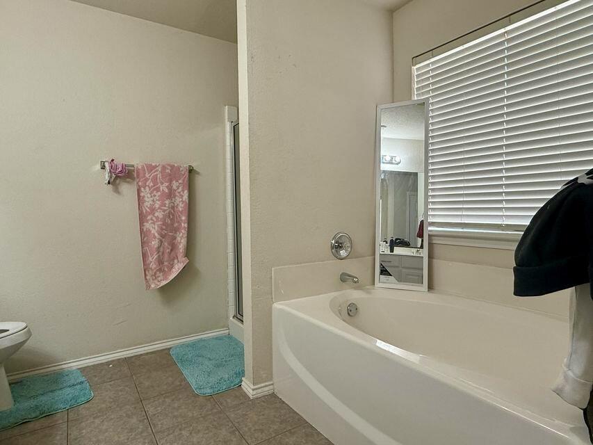 5028 Itasca Street Lubbock, TX 79416 - Photo 8 of 10 a bathroom with a bathtub and a toilet