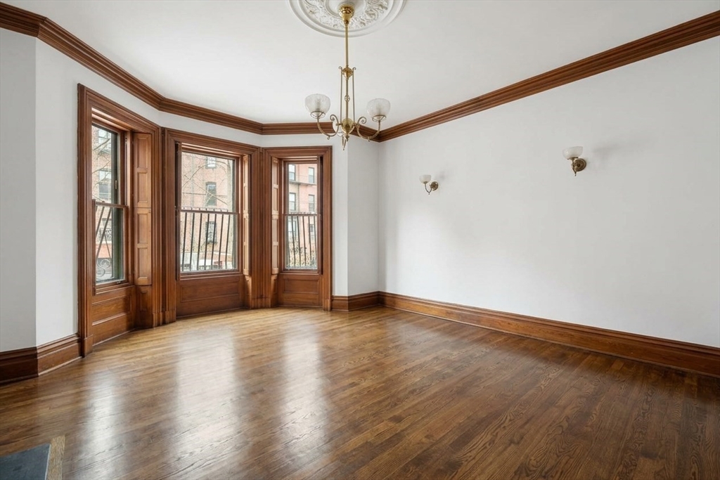 381 Beacon Street Boston, MA 02116 - Photo 2 of 21 a view of an empty room with window and wooden floor