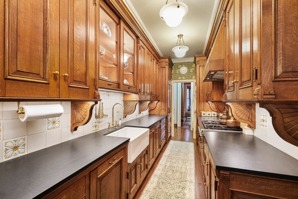 381 Beacon Street Boston, MA 02116 - Photo 3 of 21 a kitchen with stainless steel appliances a sink a stove and a wooden floor