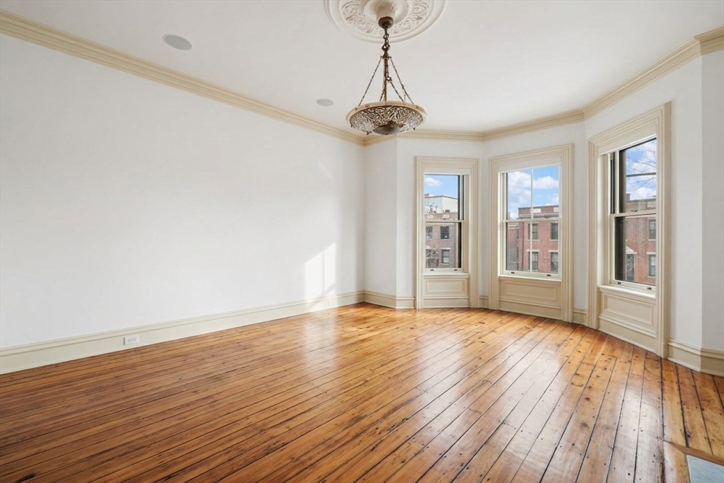 381 Beacon Street Boston, MA 02116 - Photo 9 of 21 a view of an empty room with wooden floor and a window