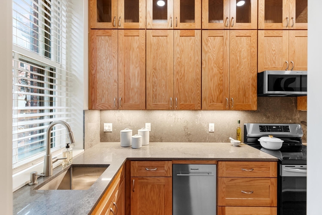 261 Marlborough Street, Unit 4R Boston, MA 02116 - Photo 19 of 36 a kitchen with stainless steel appliances granite countertop a sink a stove and a microwave