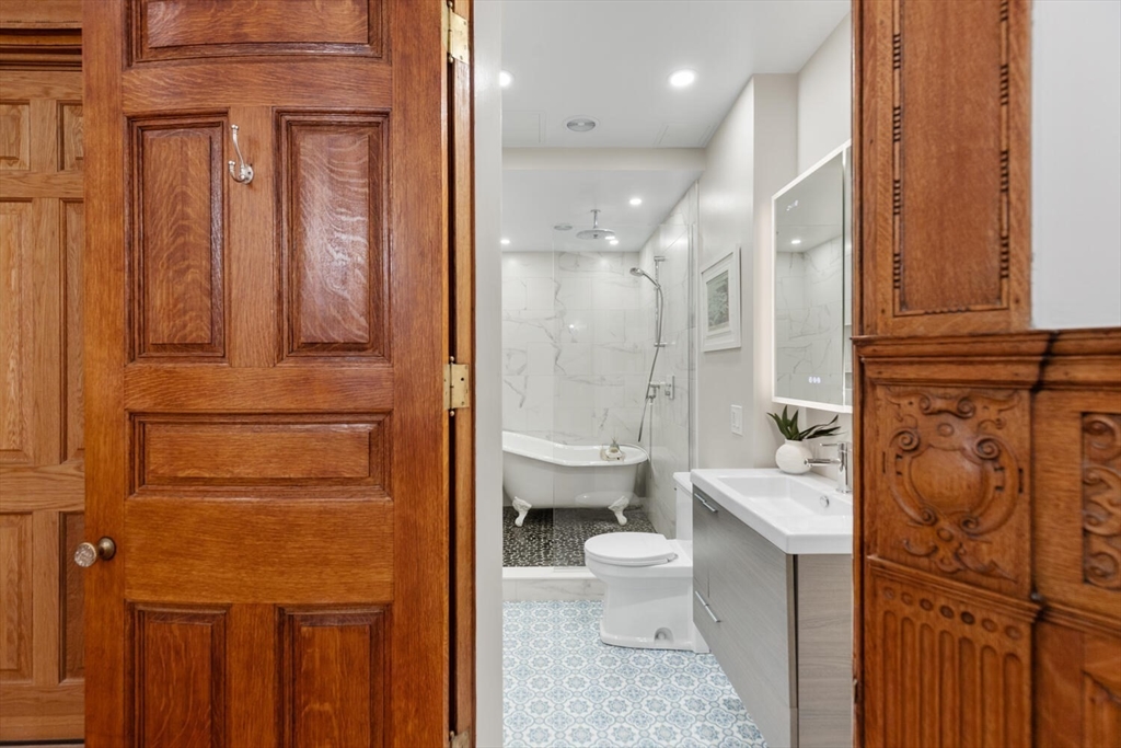 261 Marlborough Street, Unit 4R Boston, MA 02116 - Photo 25 of 36 a bathroom with a granite countertop toilet sink and shower