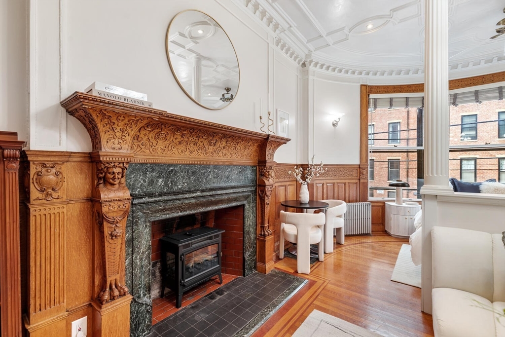 261 Marlborough Street, Unit 4R Boston, MA 02116 - Photo 9 of 36 a living room with furniture a fireplace and a large window